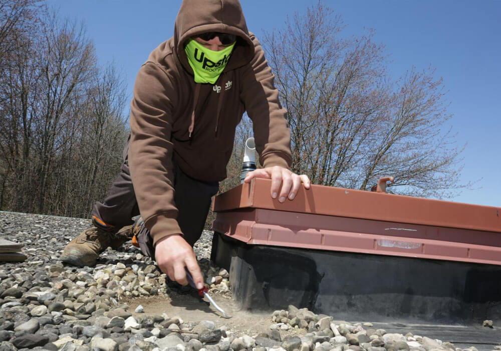 commercial Roofing Contractor Repairing Flat Roof in Rochester