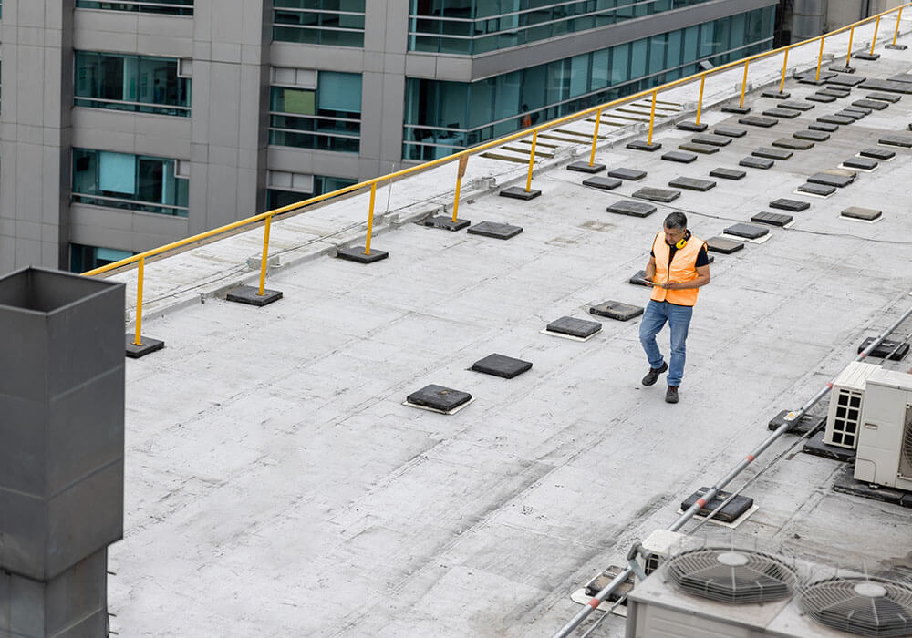 Roof Inspector Walking on Commercial Roofing System